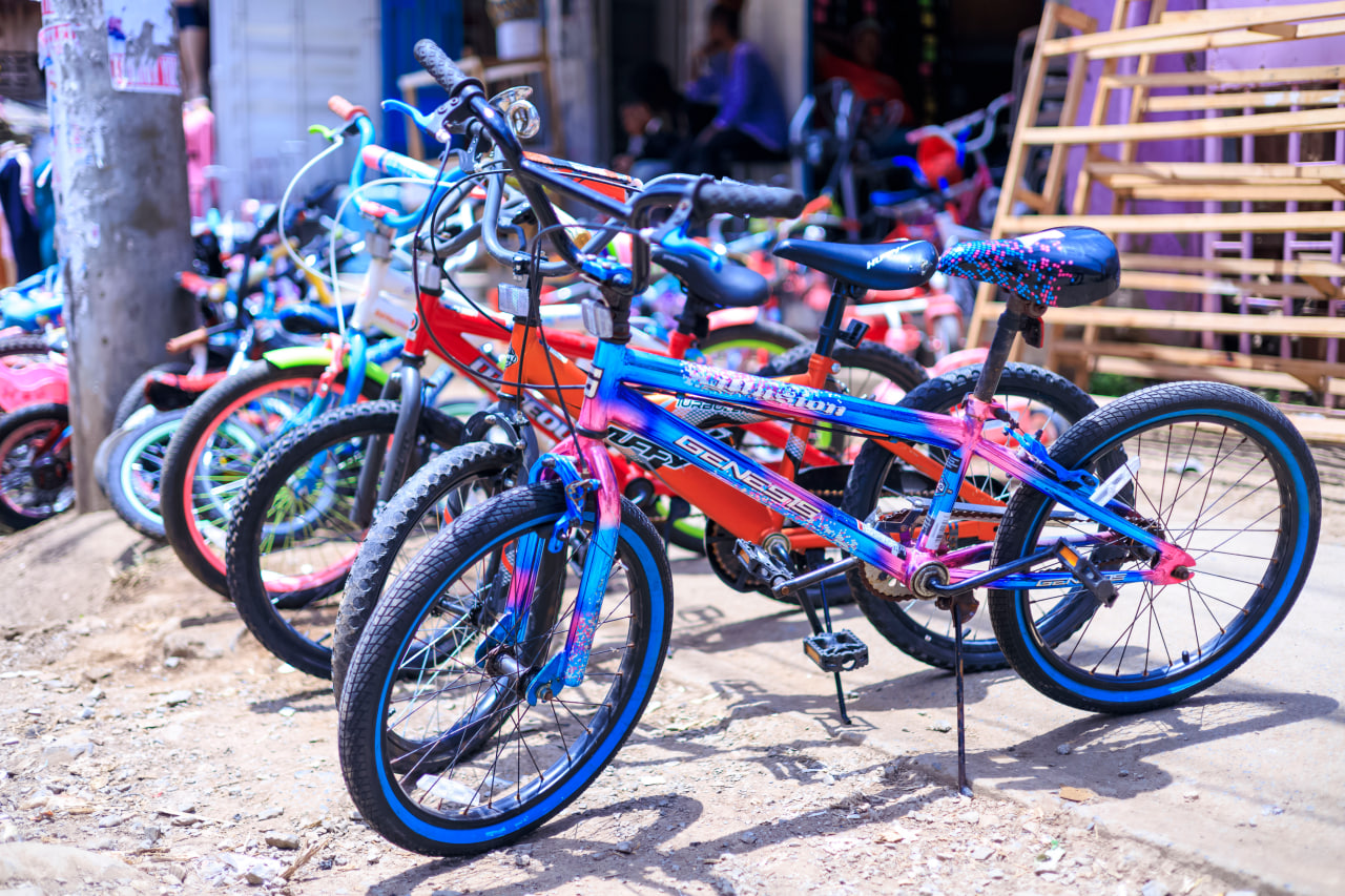 Desk with leather desk pad, walnut desk organizer, wireless keyboard and mouse, and porcelain mug.