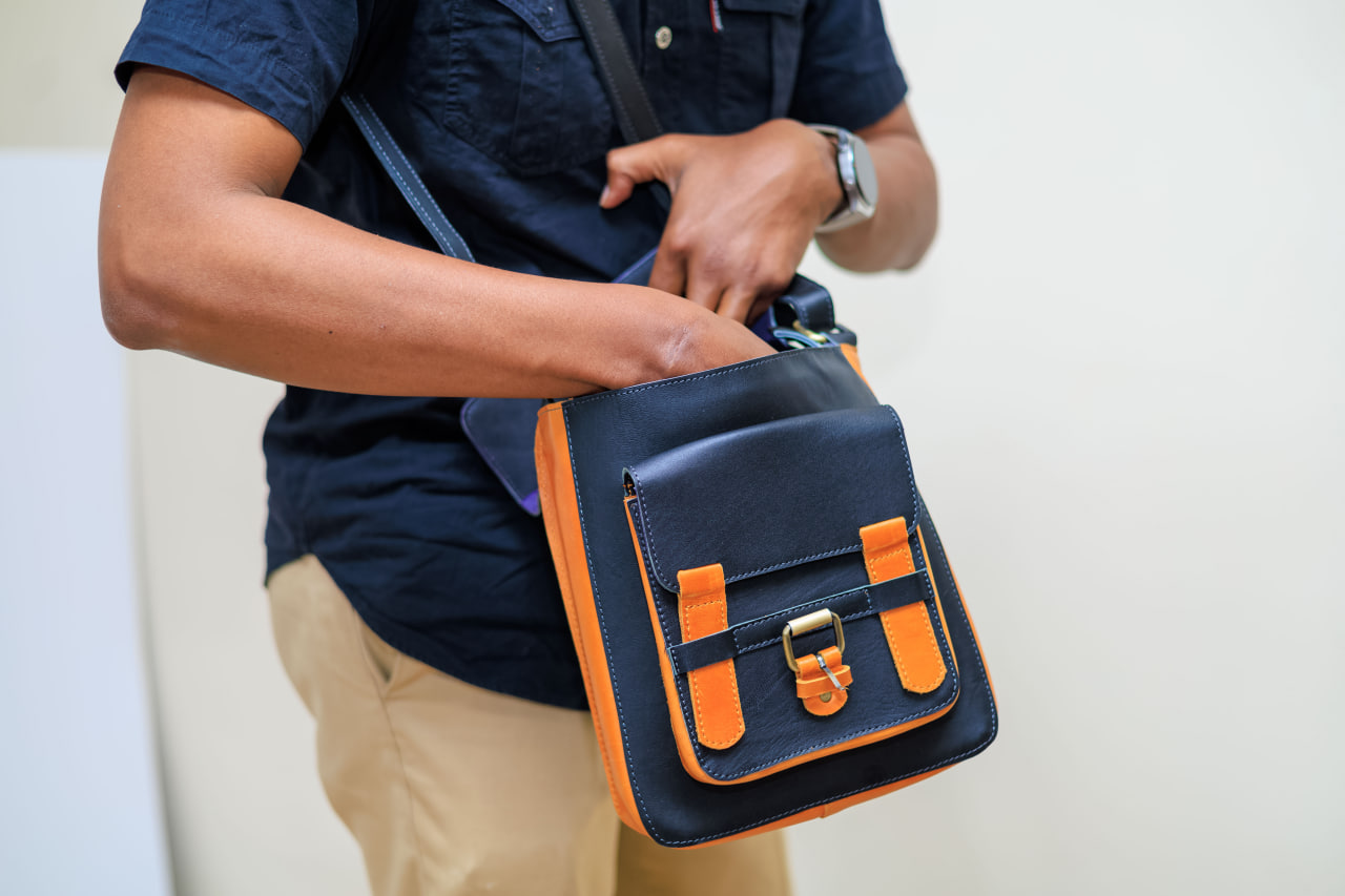 Desk with leather desk pad, walnut desk organizer, wireless keyboard and mouse, and porcelain mug.