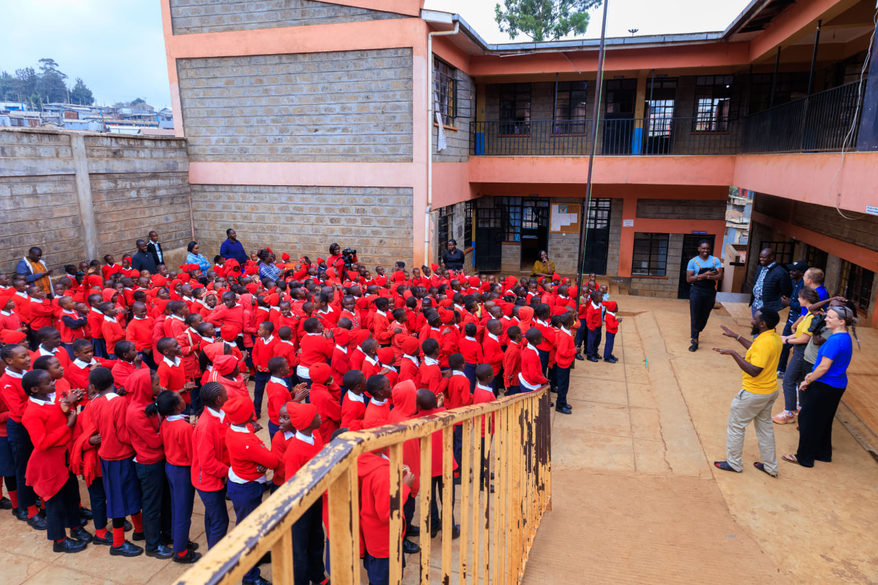Desk with leather desk pad, walnut desk organizer, wireless keyboard and mouse, and porcelain mug.
