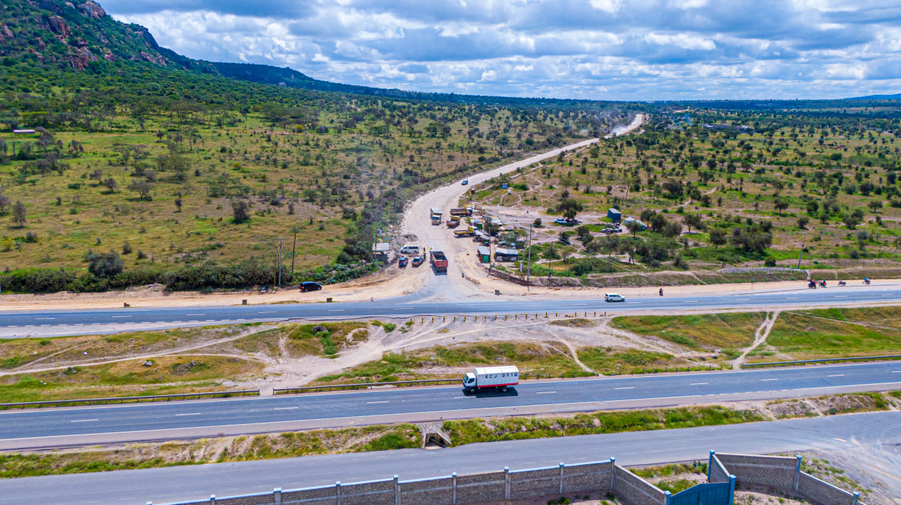 Desk with leather desk pad, walnut desk organizer, wireless keyboard and mouse, and porcelain mug.