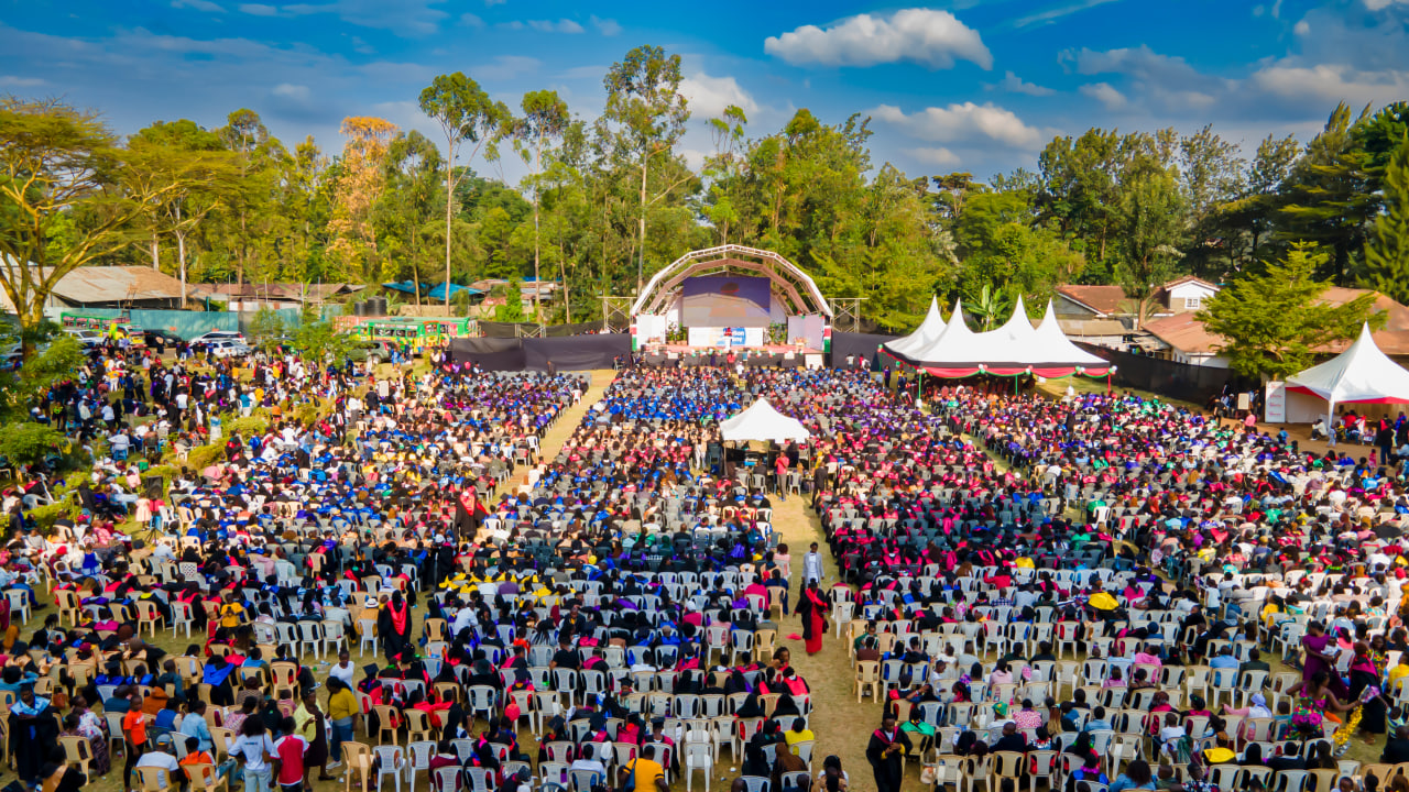 Desk with leather desk pad, walnut desk organizer, wireless keyboard and mouse, and porcelain mug.