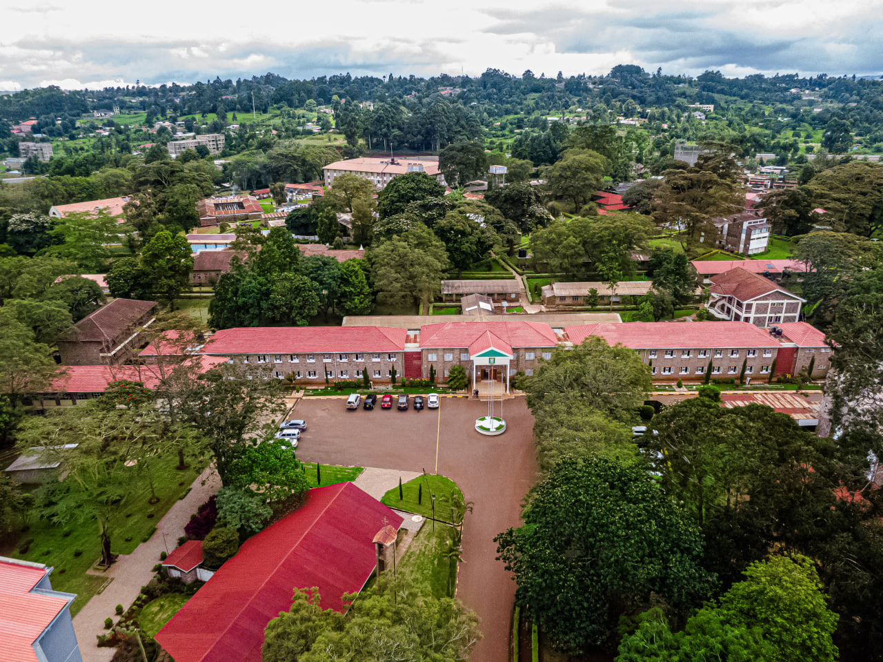 Black kettle with long pour spot and angled body on marble counter next to coffee mug and pour-over system.