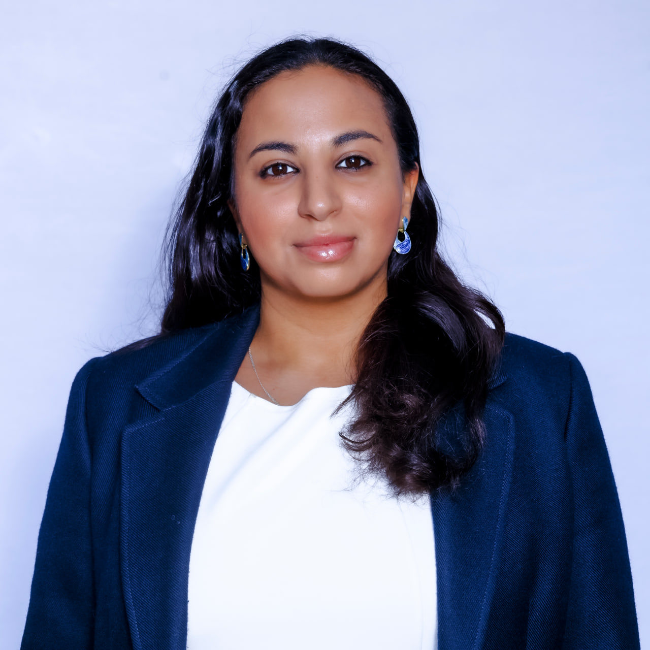 Desk with leather desk pad, walnut desk organizer, wireless keyboard and mouse, and porcelain mug.
